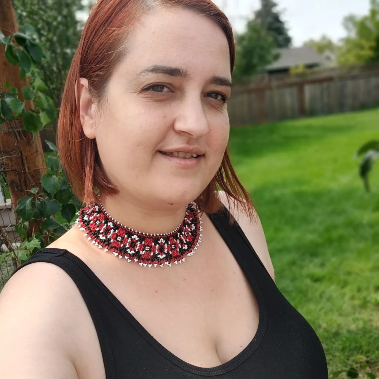 Model wearing a folk-pattern beaded choker outdoors