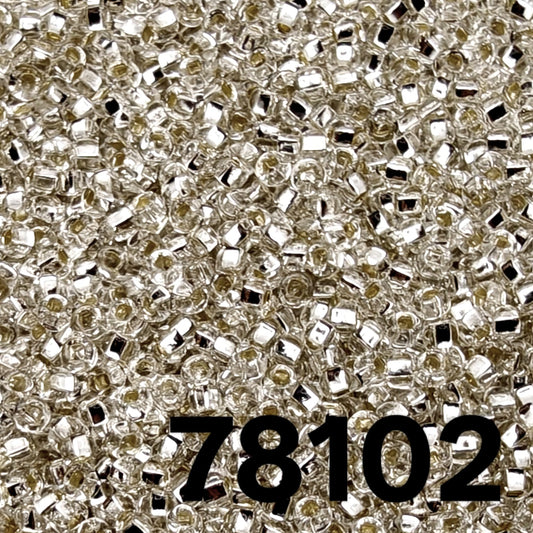 Close-up Preciosa 10/0 Silverlined Crystal seed beads 78102 — clear round rocailles with mirror-lined core, macro texture.