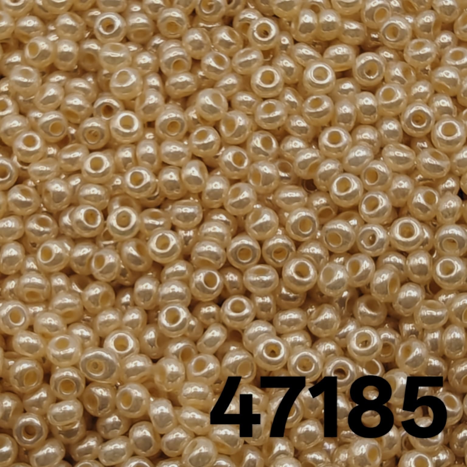 Close-up of Preciosa 10/0 pearlized seed beads in champagne shell color, code 47185