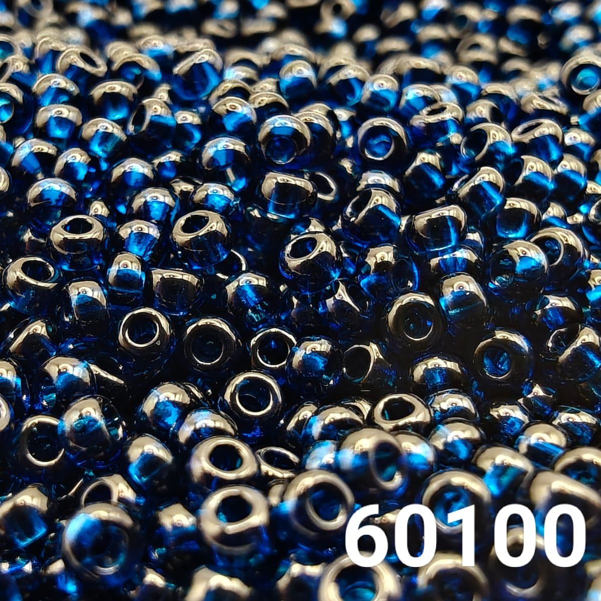 Close-up of PRECIOSA Czech round seed beads 10/0 in transparent Montana blue, colour code 60100 – polished glass beads with rich deep blue shine