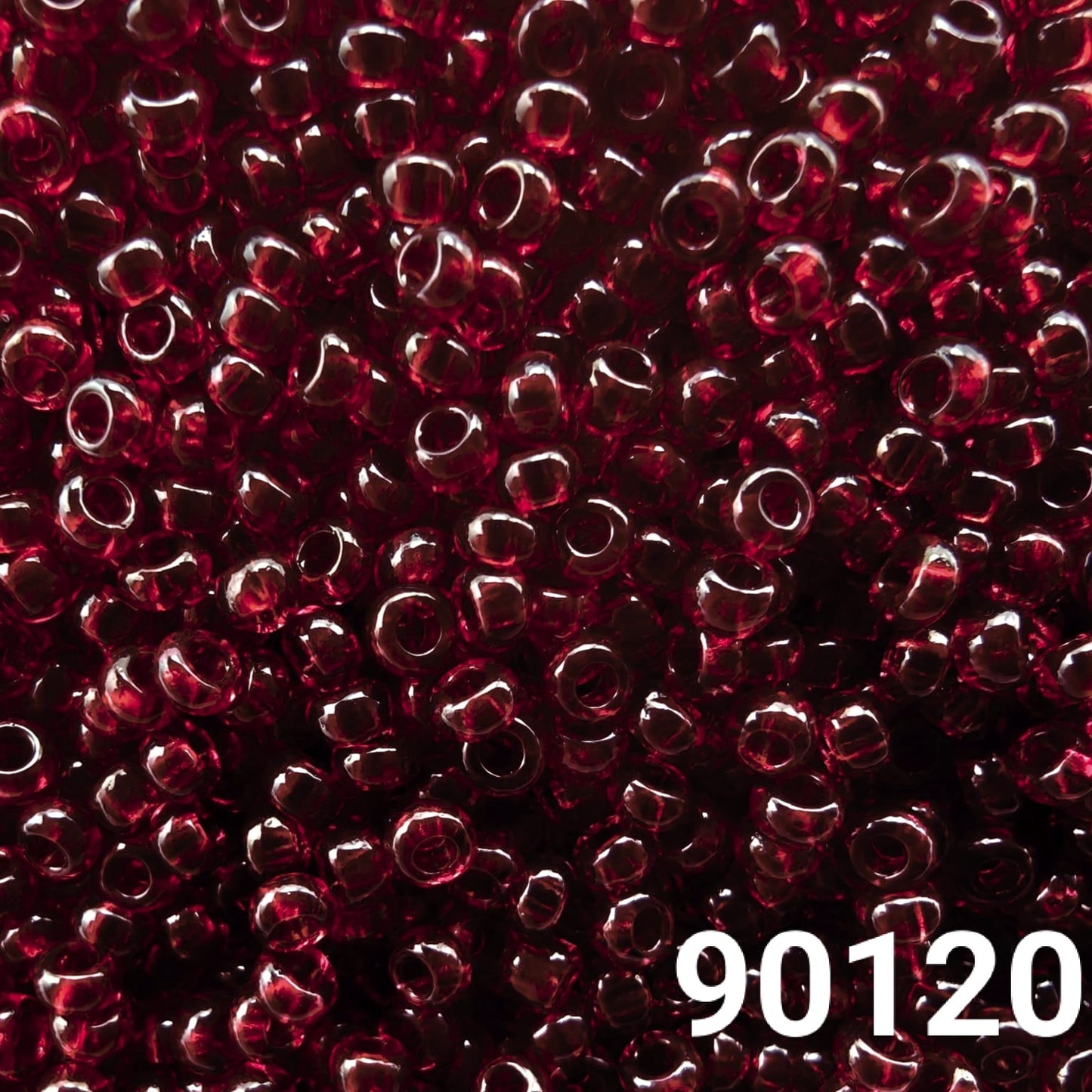 Close-up of Preciosa 10/0 seed beads in transparent dark red color (90120)