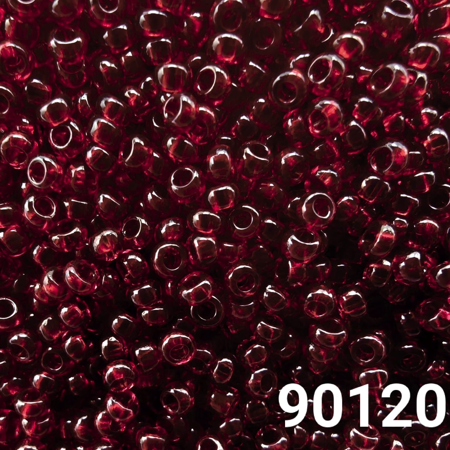Close-up of Preciosa 10/0 seed beads in transparent dark red color (90120)