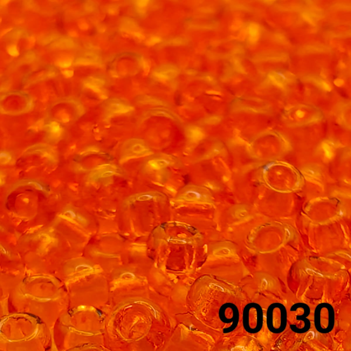 Close-up view of PRECIOSA Czech seed beads 10/0 in transparent orange hyacinth, colour code 90030 – round glass beads with smooth finish