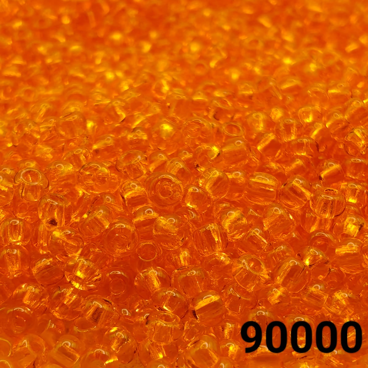 Close-up of PRECIOSA Czech 10/0 seed beads in transparent light orange, colour code 90000 – round glass beads with polished finish