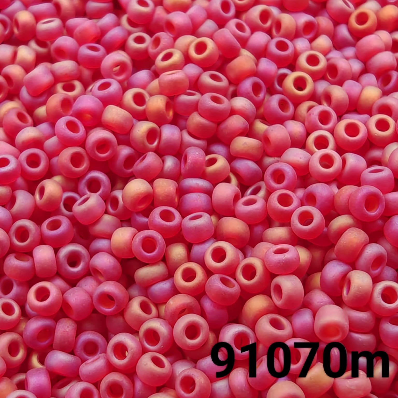 Close-up of Preciosa 10/0 seed beads in frosted rainbow transparent red color (91070m)
