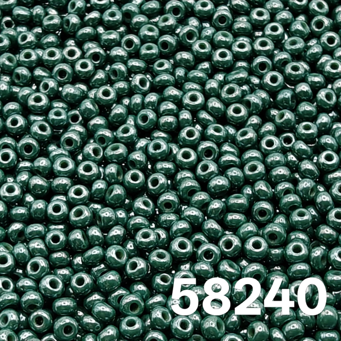 Macro close-up of Preciosa 10/0 Opaque Luster Dark Green (58240) round seed beads — deep evergreen, glossy luster, Czech glass.