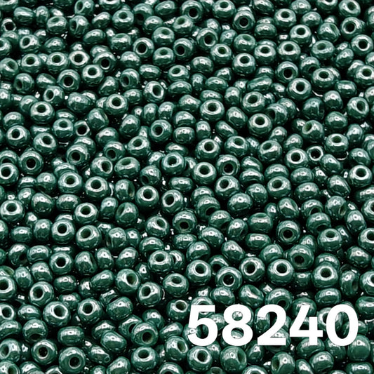 Macro close-up of Preciosa 10/0 Opaque Luster Dark Green (58240) round seed beads — deep evergreen, glossy luster, Czech glass.