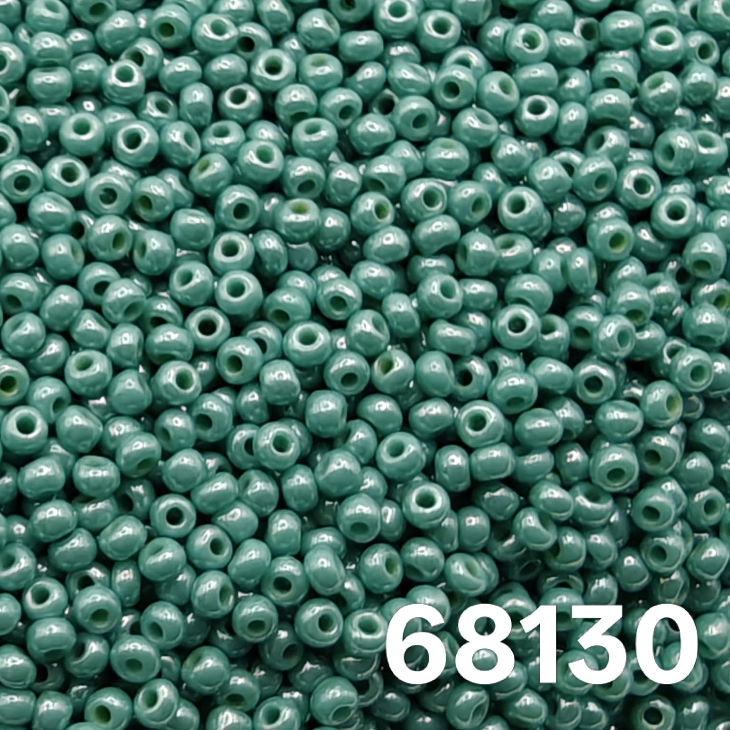 Macro close-up of Preciosa 10/0 Opaque Luster Green Turquoise (68130) round seed beads — cool sea-green with glossy luster, Czech glass.