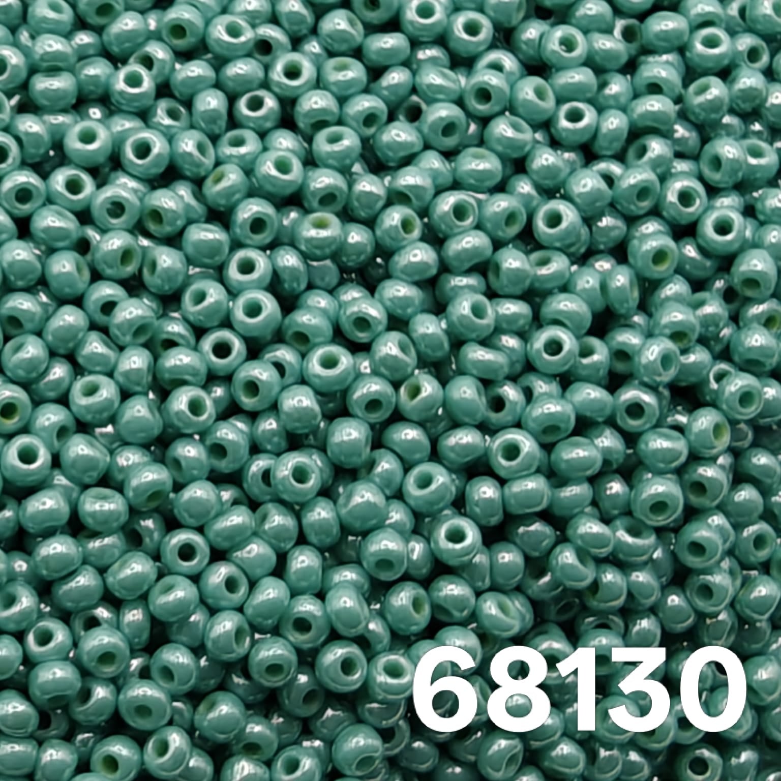 Macro close-up of Preciosa 10/0 Opaque Luster Green Turquoise (68130) round seed beads — cool sea-green with glossy luster, Czech glass.