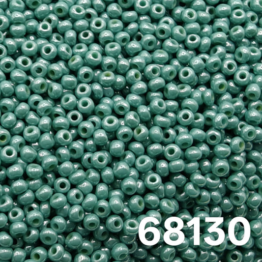 Macro close-up of Preciosa 10/0 Opaque Luster Green Turquoise (68130) round seed beads — cool sea-green with glossy luster, Czech glass.