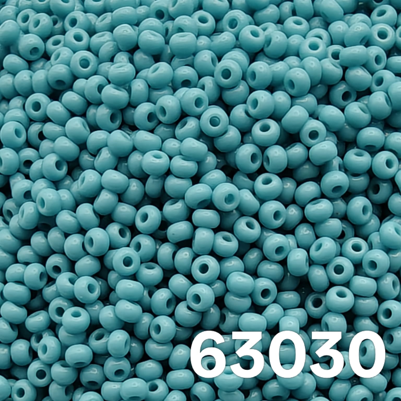Macro close-up of Preciosa 10/0 Opaque Medium Turquoise (63030) round seed beads — smooth solid lagoon-blue, glossy Czech glass.