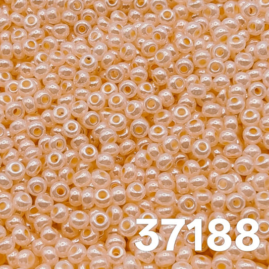 Macro close-up of Preciosa 10/0 Pearlized Orange Ceylon (37188) round seed beads — soft apricot/peach with satin ceylon luster, Czech glass.