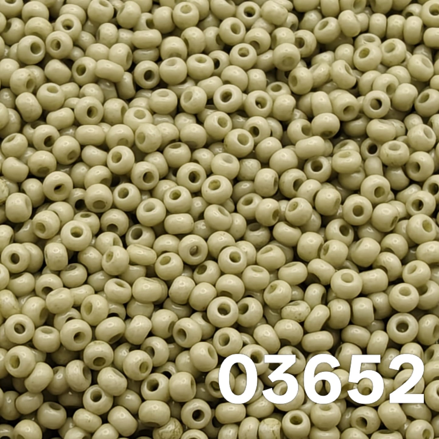 Macro close-up of Preciosa 10/0 Solgel Chalk Yellow-Green (03652) round seed beads — soft pistachio/sage opaque, glossy Czech glass.