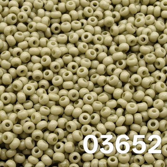 Macro close-up of Preciosa 10/0 Solgel Chalk Yellow-Green (03652) round seed beads — soft pistachio/sage opaque, glossy Czech glass.