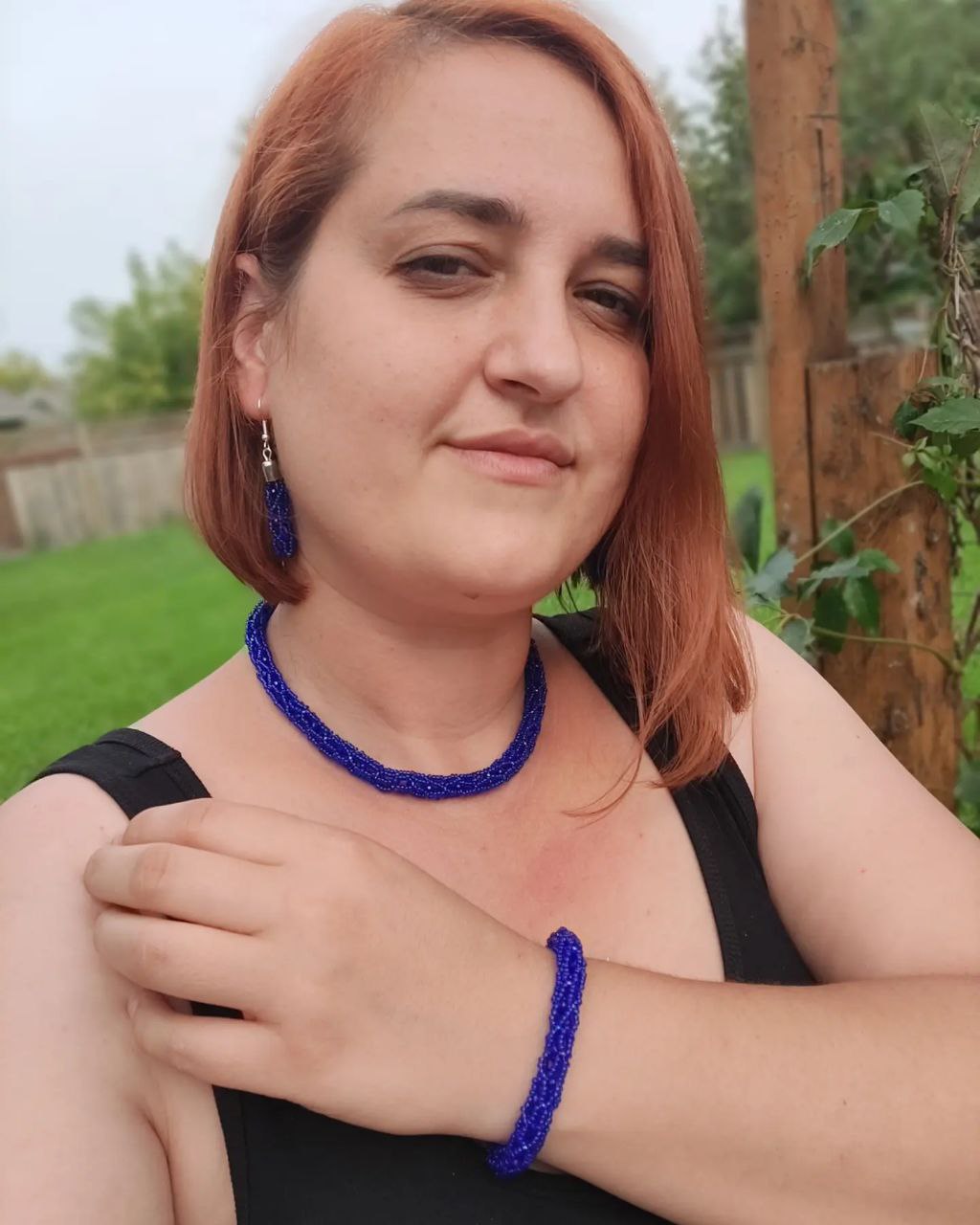 Model wearing cobalt beaded necklace and bracelet outdoors