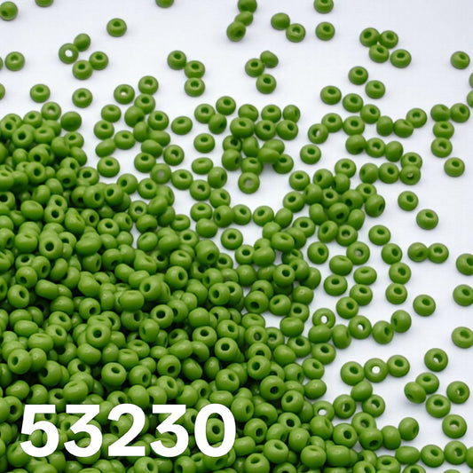 Opaque light green size 10 Preciosa seed beads 53230 scattered on white background