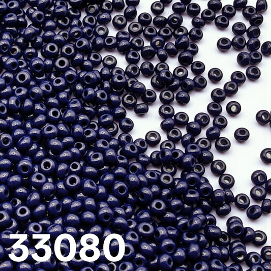 Preciosa 10/0 opaque dark blue seed beads 33080 scattered on white background