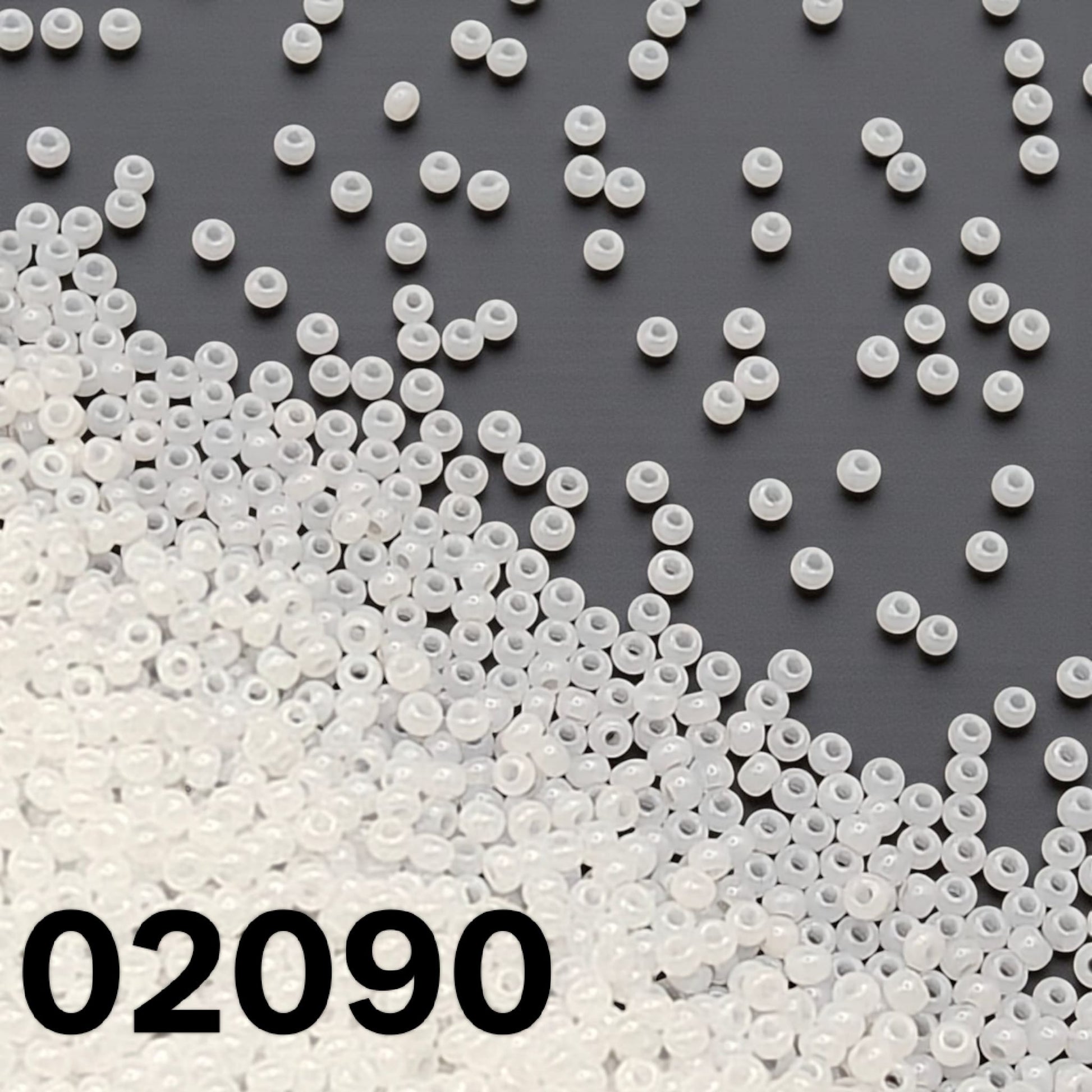 Preciosa 10/0 opaque white alabaster Czech seed beads 02090 scattered on dark background – Beadsy.ca