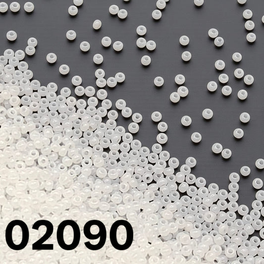 Preciosa 10/0 opaque white alabaster Czech seed beads 02090 scattered on dark background – Beadsy.ca