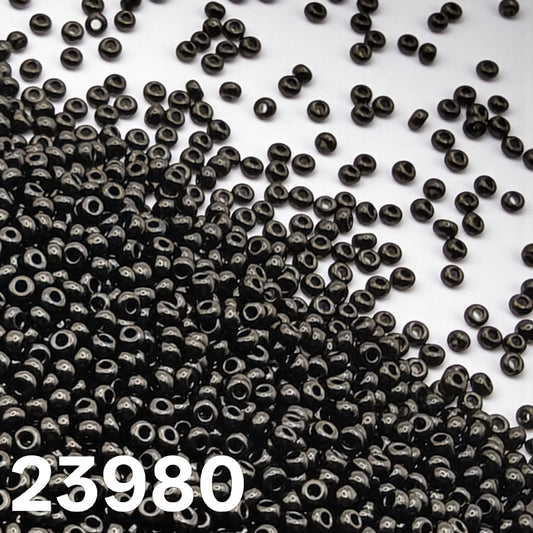 Preciosa Czech seed beads 10/0 Opaque Black 23980 scattered on white background close up – Beadsy.ca