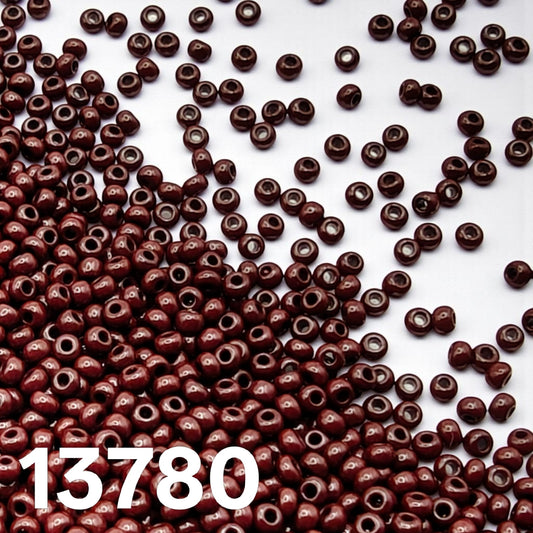 Preciosa Czech seed beads 10/0 opaque dark brown 13780 scattered on white background