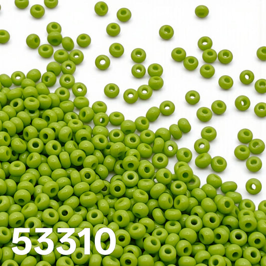 preciosa 10/0 opaque pale green seed beads 53310 scattered on white background